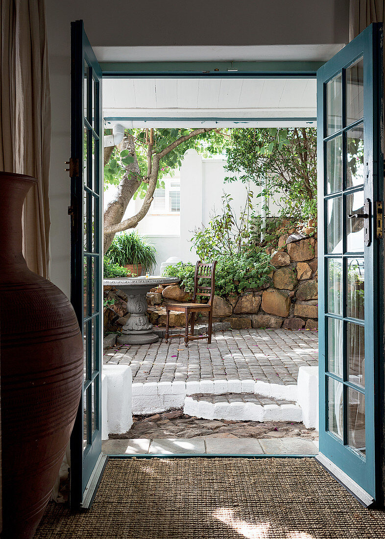 View through open double doors into summery courtyard