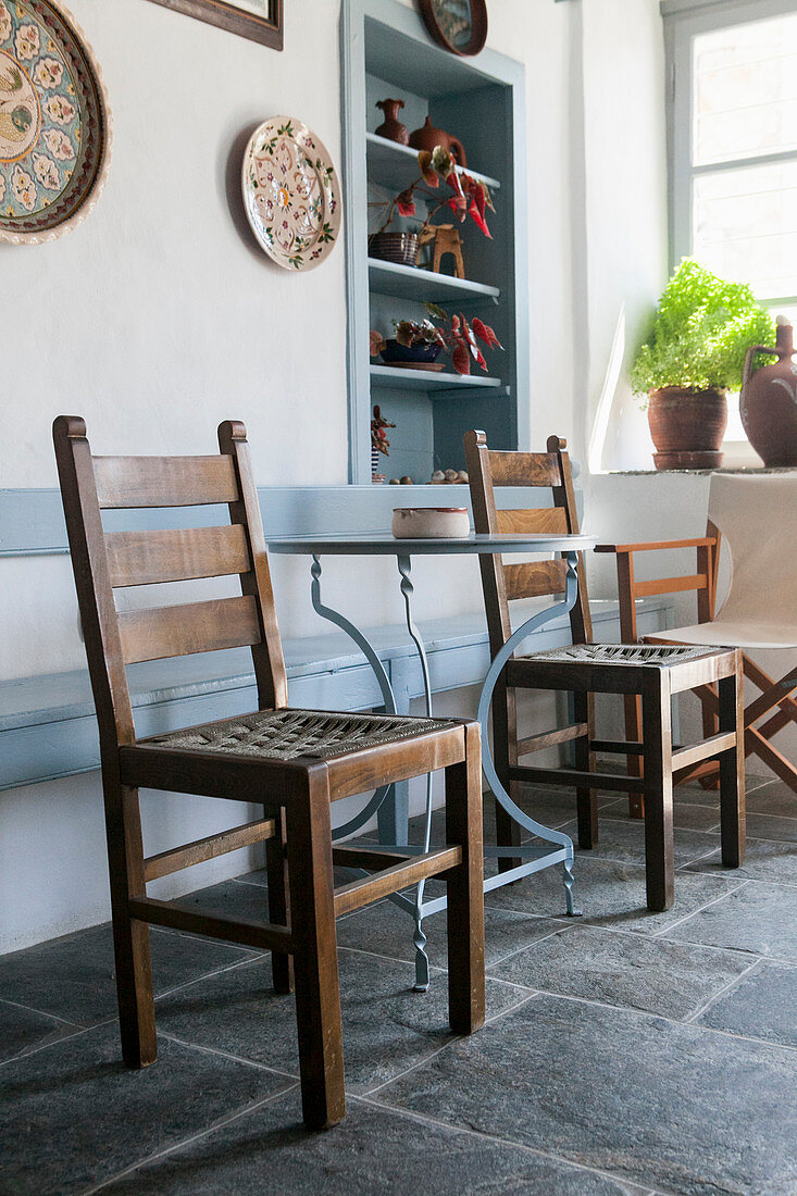 Bistro table and wooden chairs in house in Greece