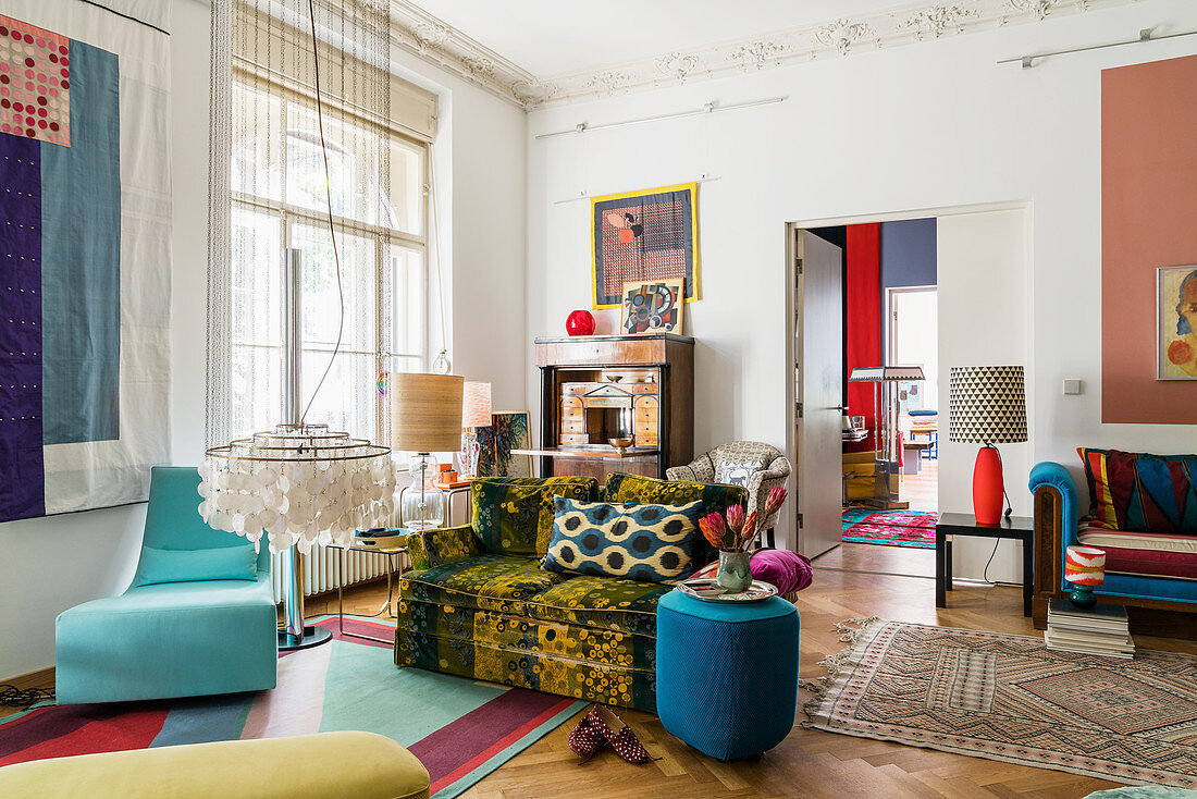 Various seats with colourful upholstery and classic pendant lamp in living room