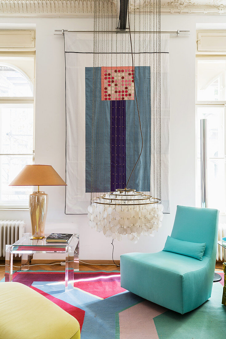 Designer-Schaukelsessel in Hellblau, Klassiker Hängeleuchte, Beistelltisch und Wandbehang im Wohnzimmer