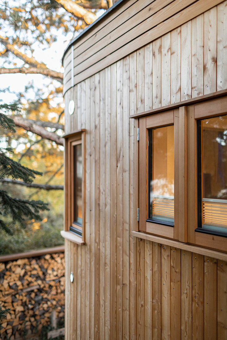 Holzverkleideter runder Anbau eines Tiny Houses mit mehreren kleinen Fenstern