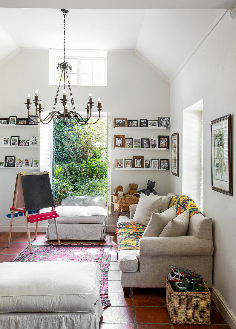 Sofa and photos of children on shelves in renovated farmhouse