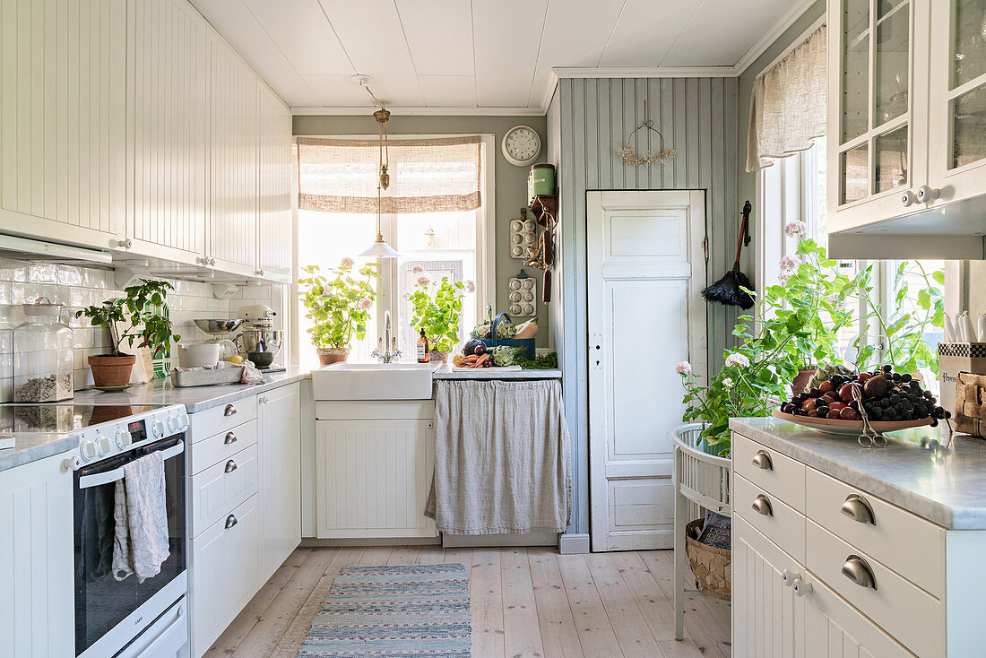 Küche ist im klassischen Landhausstil mit weißer Front