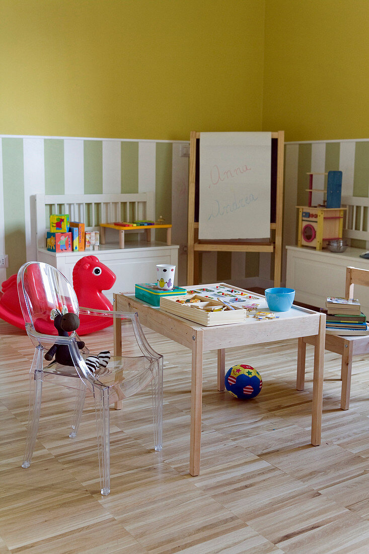 Spielbereich im Kinderzimmer mit Holzstuhl und Ghoststuhl an Maltisch