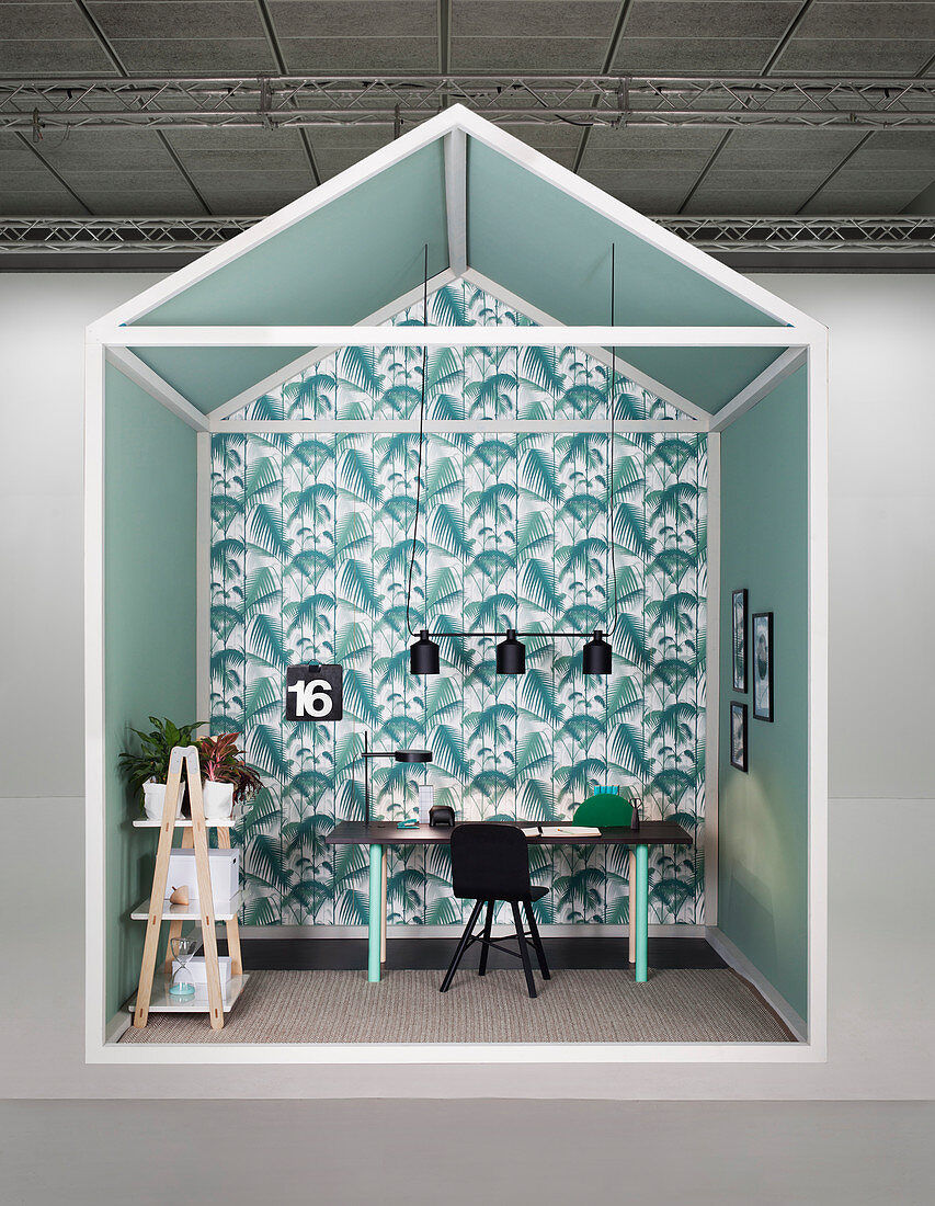 Creative design for study area with desk against wall covered in leaf-patterned wallpaper