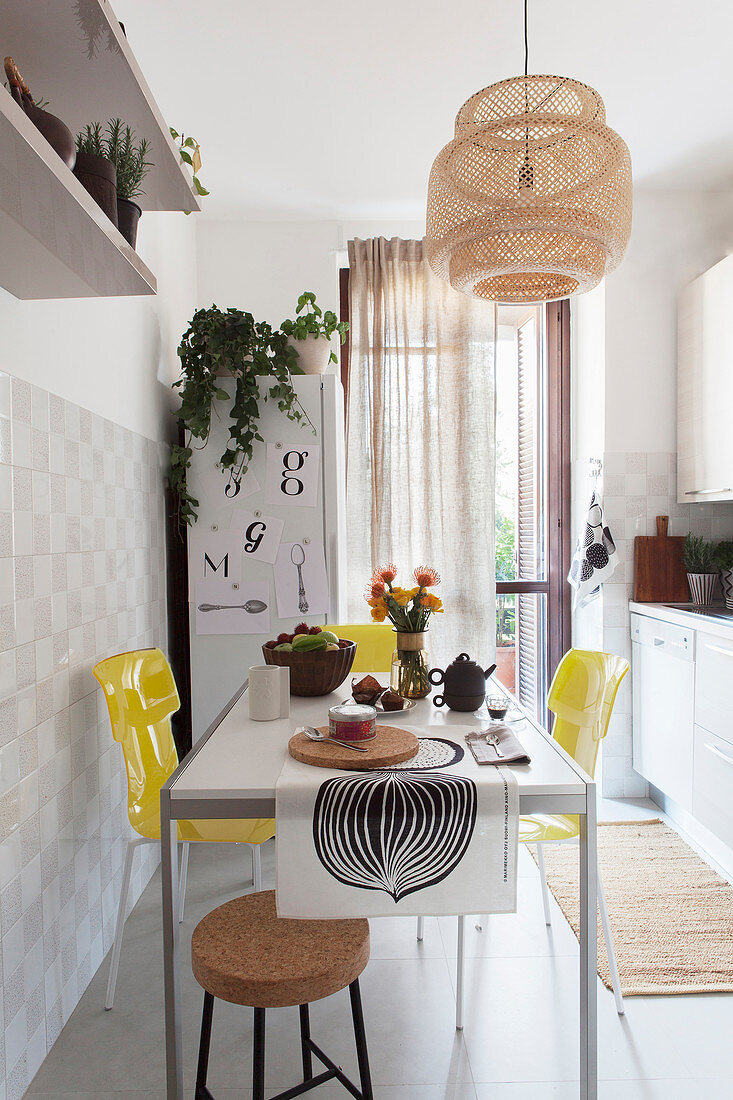 Helle Küche mit beigefarbenen Akzenten und Esstisch mit zitronengelben Stühlen