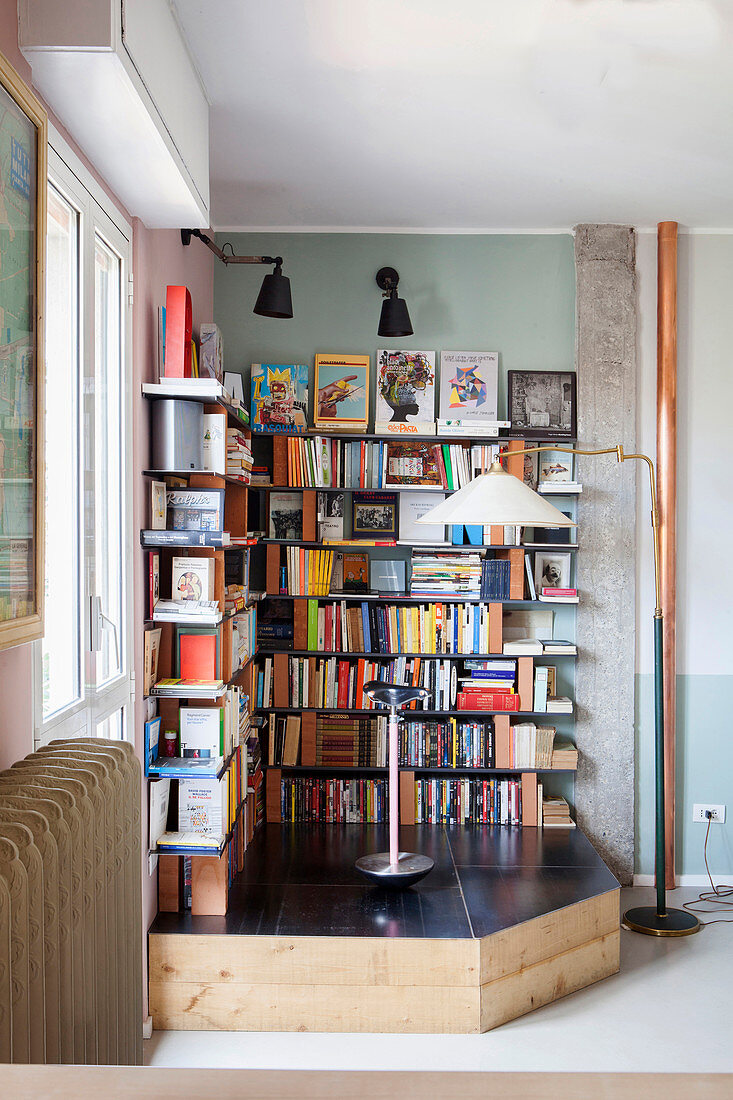 Bücherregal aus Ziegelsteinen und Metallregalen auf Podest in Zimmerecke