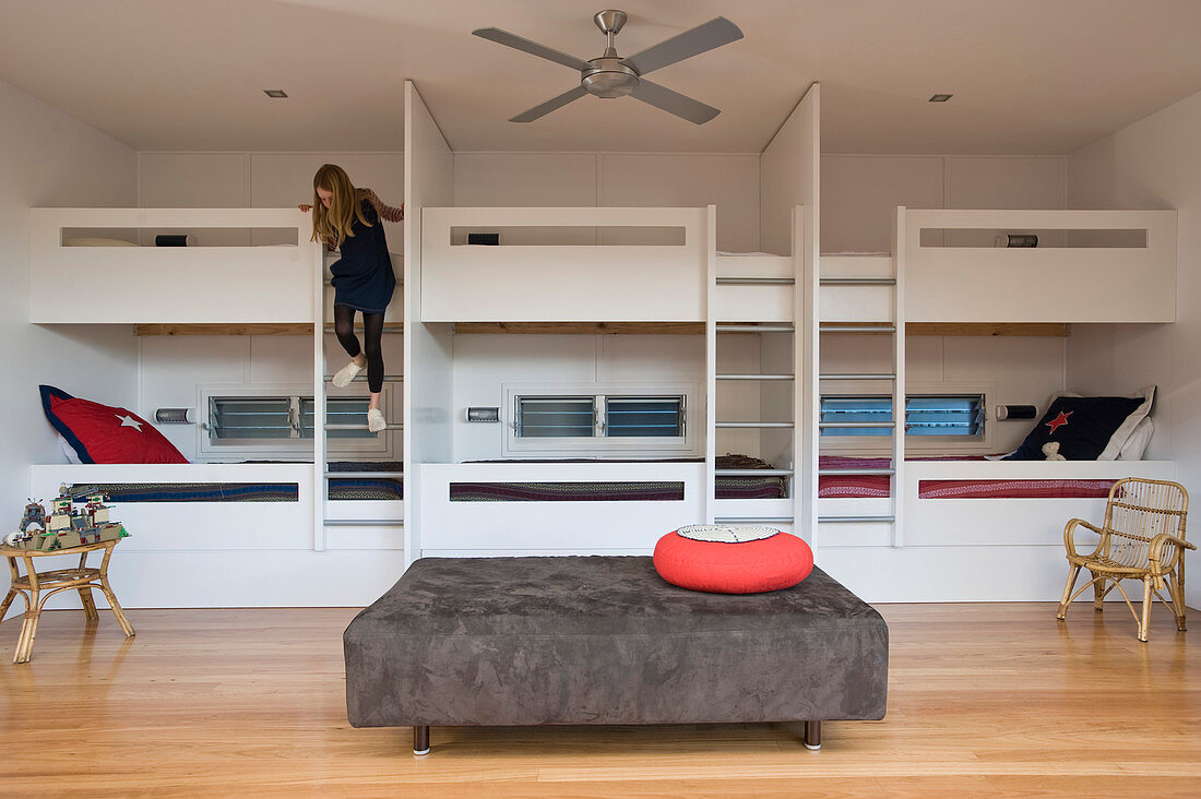 Bunk beds in bedroom with girl climbing down ladder