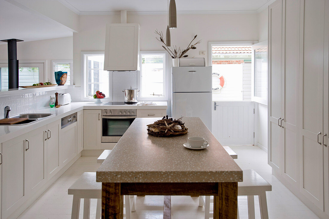 Holztisch mit Marmorplatte und Hocker in weißer Küche