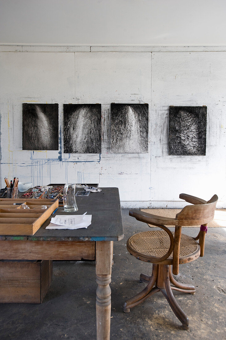 Holztisch mit Stuhl, moderne Kunst an der Wand im Arbeitsraum