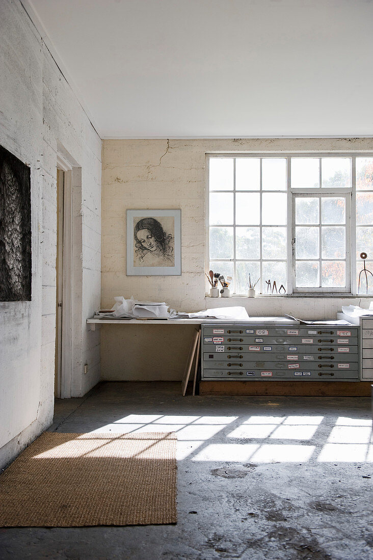 Industrial-style tabletop and chest of drawers below lattice window