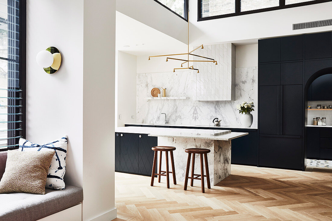 Offene Küche mit schwarzen Einbauten und Marmor in hohem Wohnraum