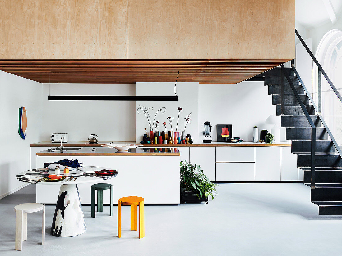 Bright, open kitchen with black metal stairs to the gallery
