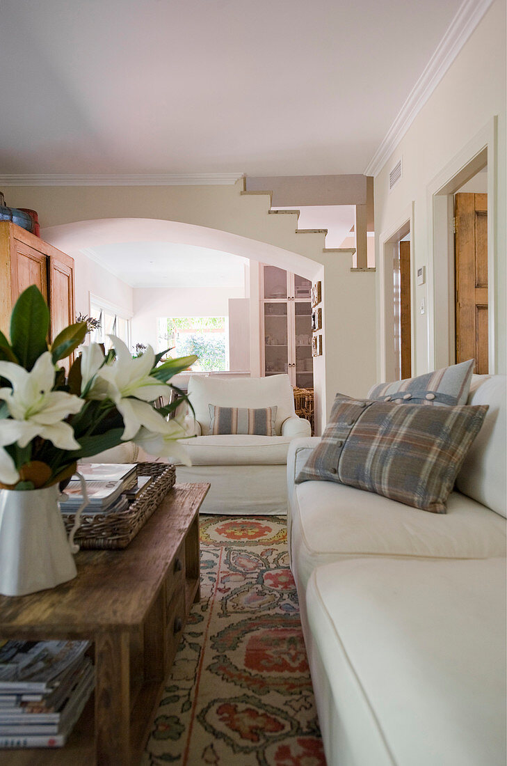 Wohnzimmer im Landhausstil mit rustikalem Holz-Couchtisch und weißen Sitzmöbeln
