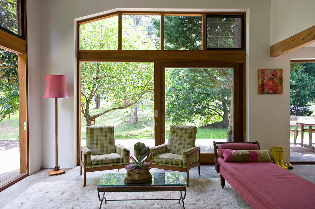 Wohnraum mit Holzrahmen-Fensterfronten und Möbeln im Retrostil