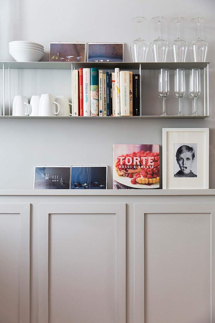 Glasses and crockery on simple shelves above wainscoting