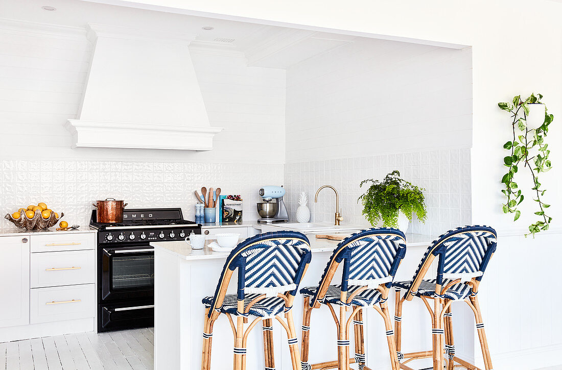 Rattan barstools with blue woven seats at kitchen counter