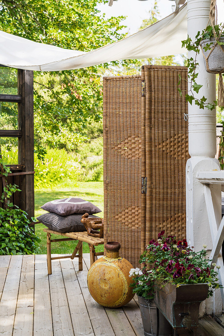 Wicker screen and vintage-style accessories on cosy terrace