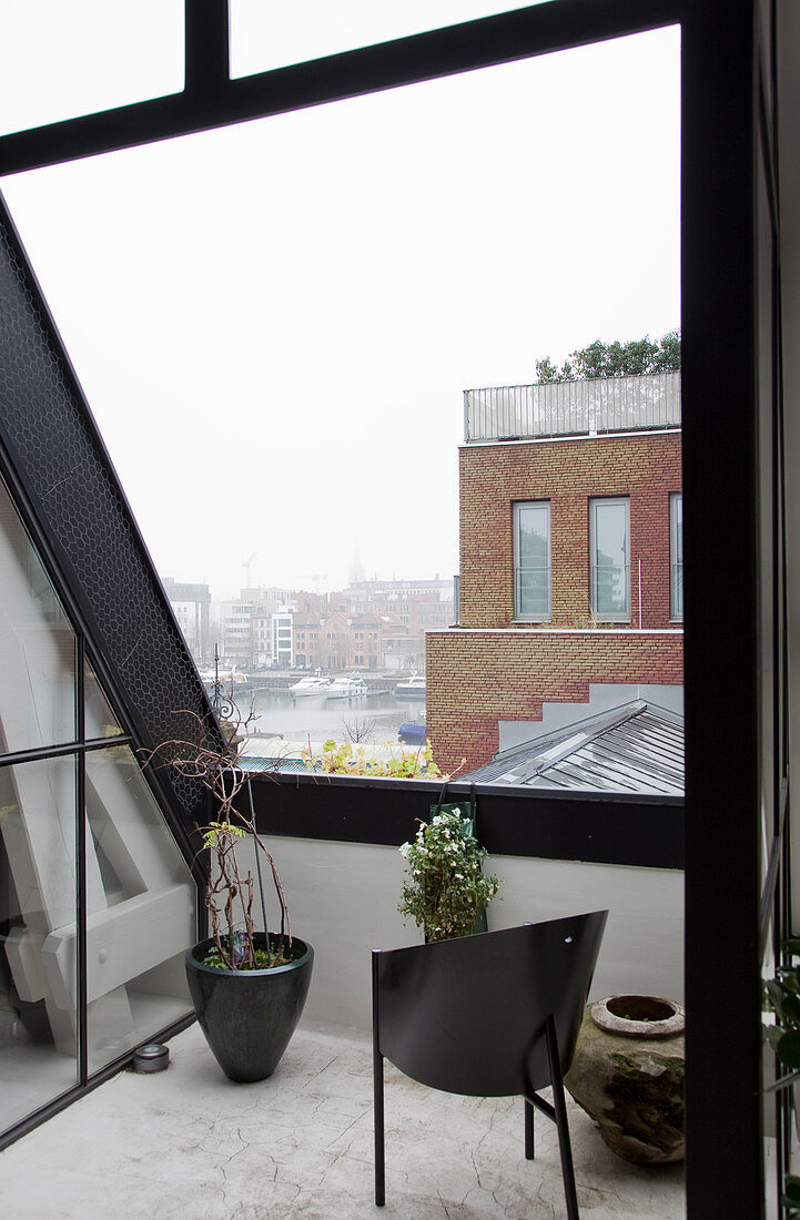 Loggia with black frame and view over misty town