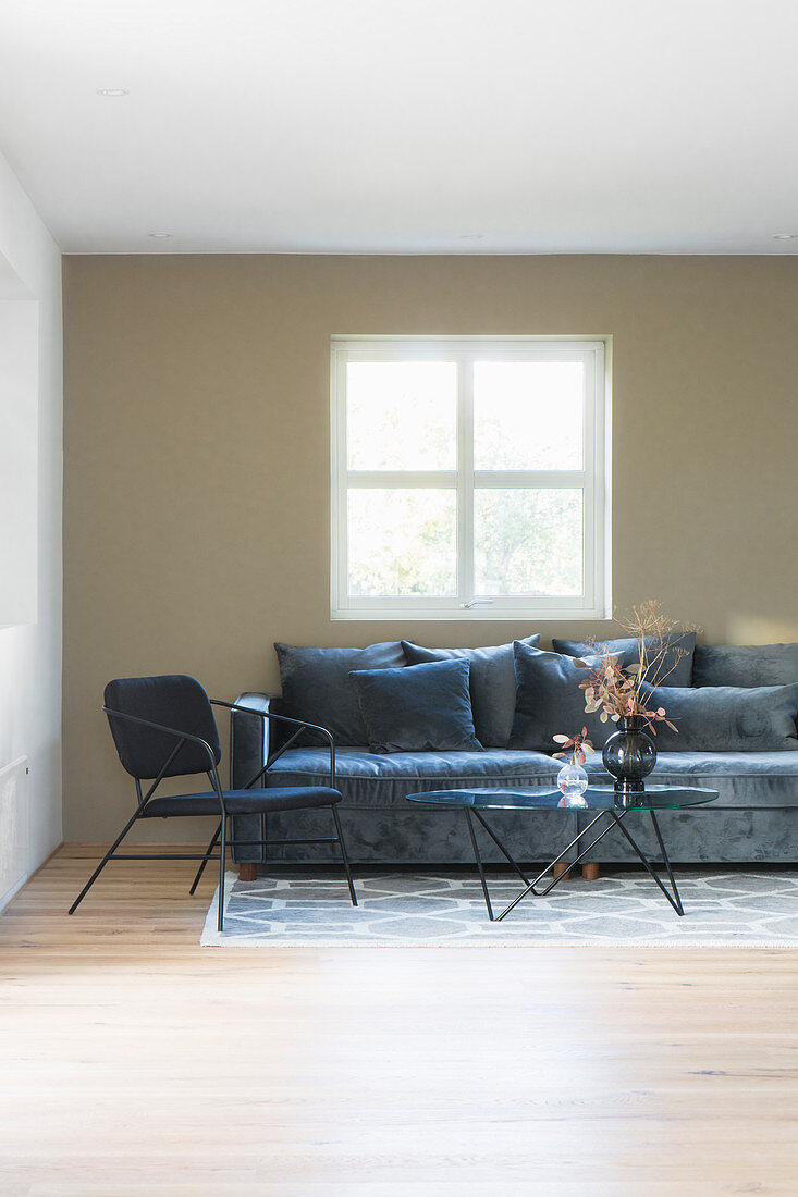 Grey sofa, chair and coffee table in living room with olive-green wall