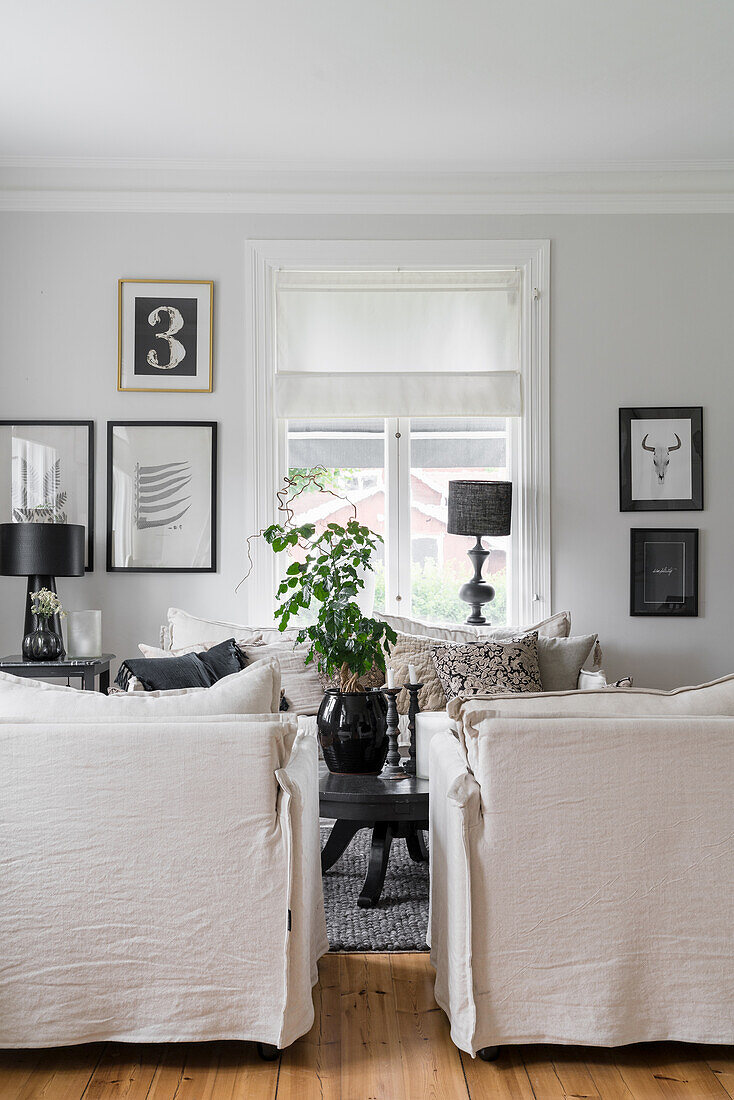 Hussensessel und schwarz-weiße Drucke an der Wand im Wohnzimmer