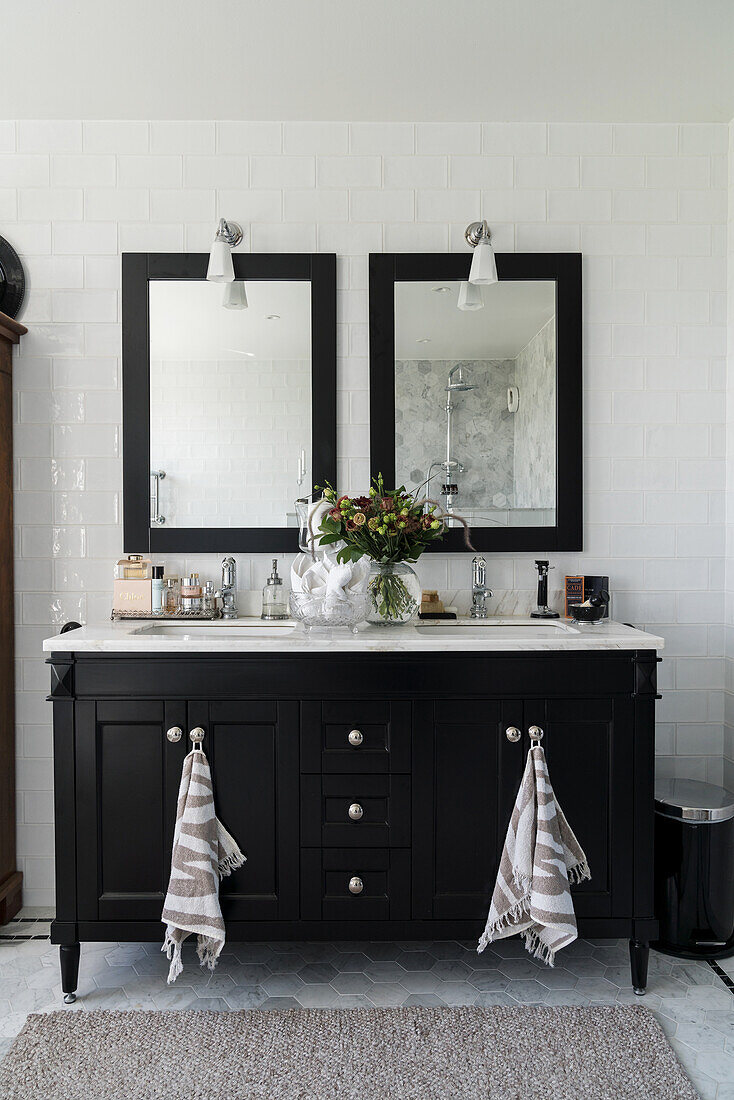 Black vanity unit with twin washbasins and two mirrors