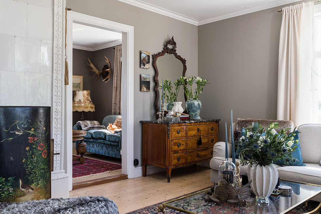 Antike Kommode und Spiegel im Wohnzimmer mit grauen Wänden