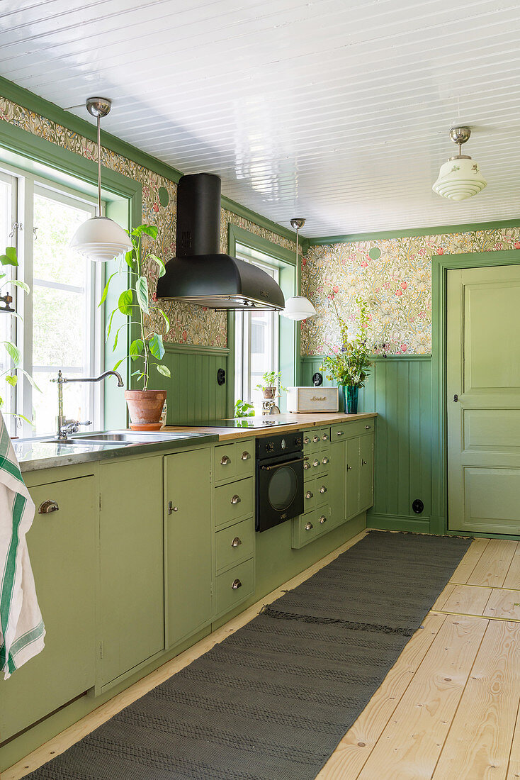 Grüne Unterschränke und nostalgische Tapete in der Küche