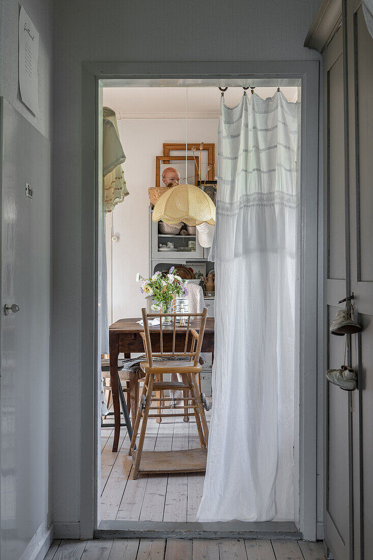 View through half-open door curtain into dining area
