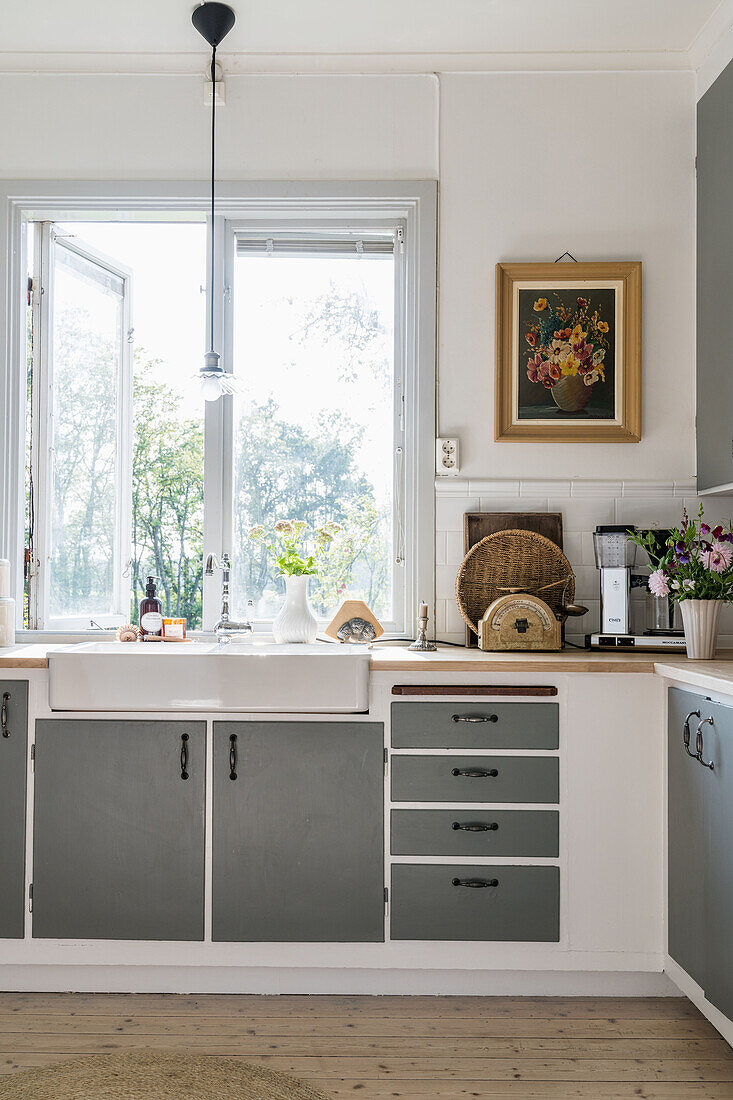 Küche mit grauen Schrankfronten im Landhausstil, Fenster mit Gartenblick
