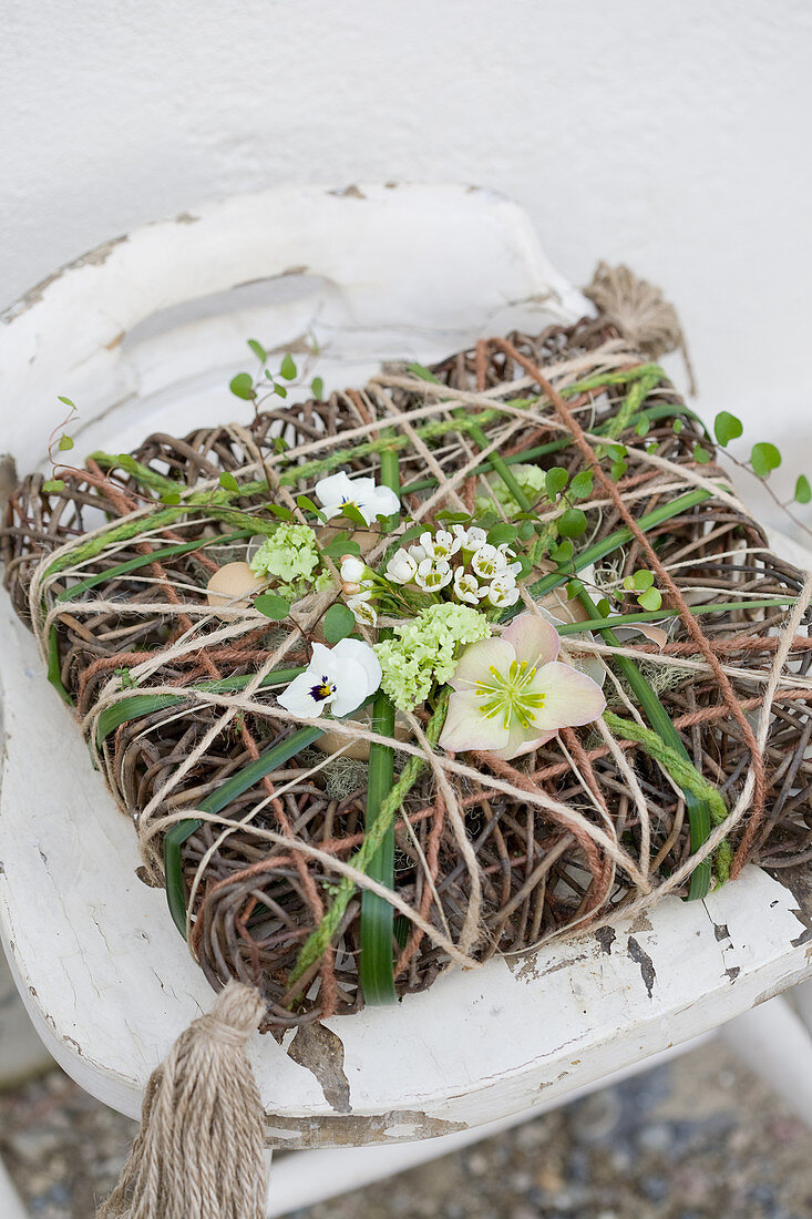 Dekoratives Kissen aus Draht, Schnur und Frühlingsblumen