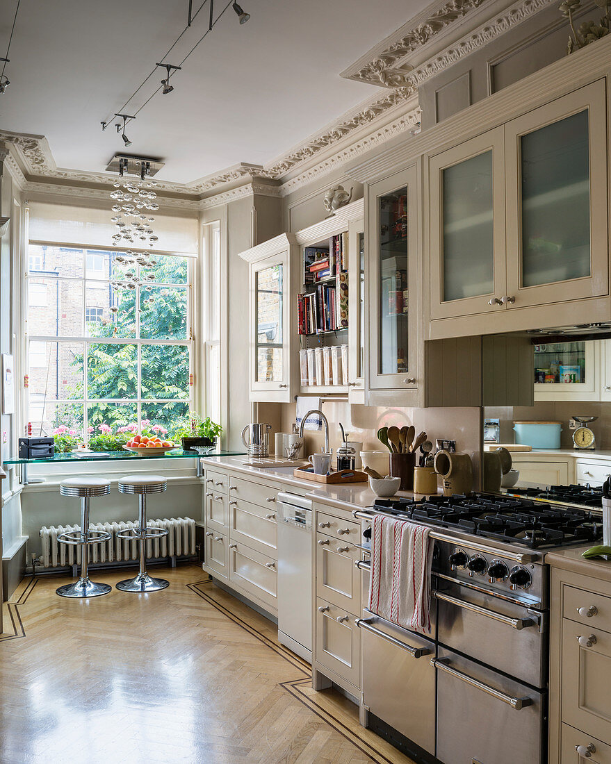 Classic kitchen in pale grey with antique stucco details and parquet floor