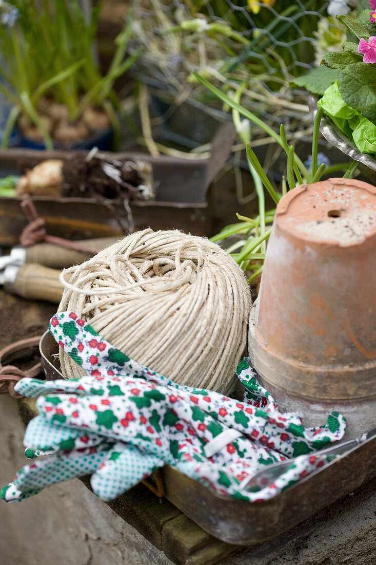 Still-life arrangement of terracotta pot, twine and work gloves