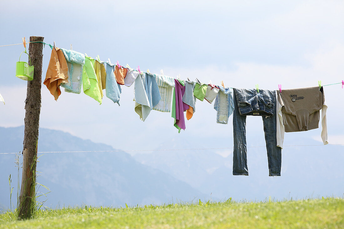 Wäsche auf Leine vor blauem Himmel und Bergpanorama