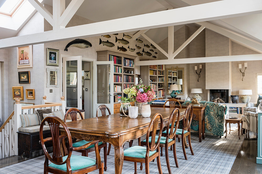 Antique dining table in open-plan interior with exposed roof structure