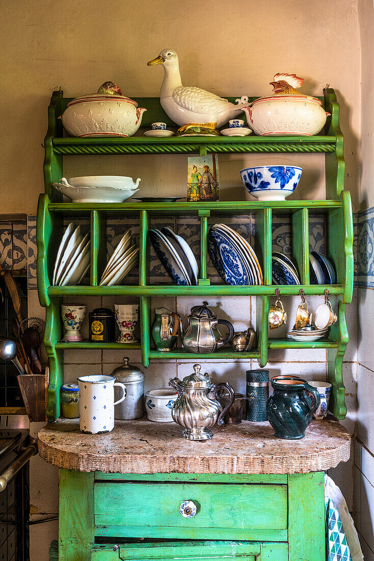 Alte, grün gestrichene Tellerregal in ländlicher Küche