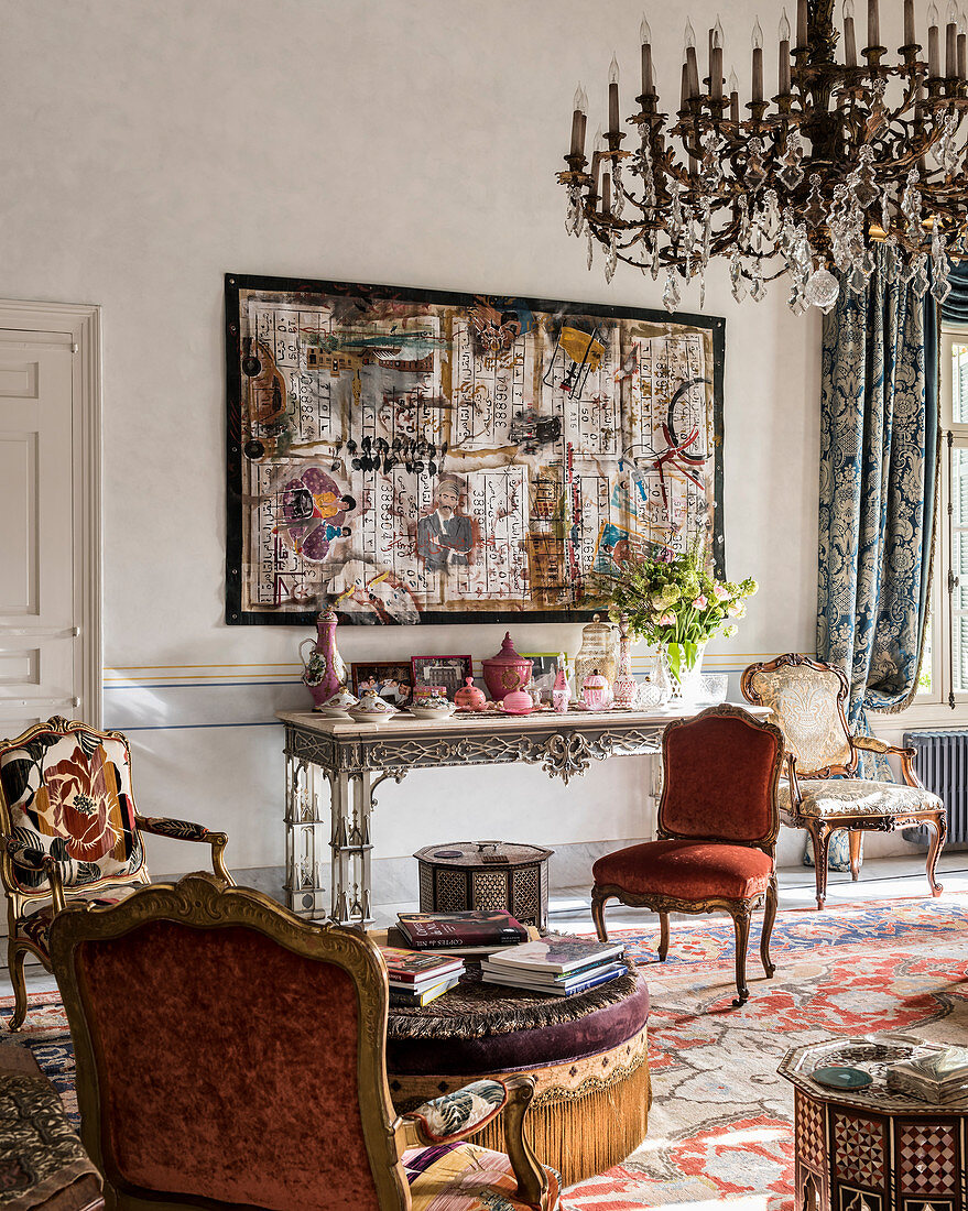 Collage überm Konsolentisch im Wohnzimmer mit barocken Stühlen