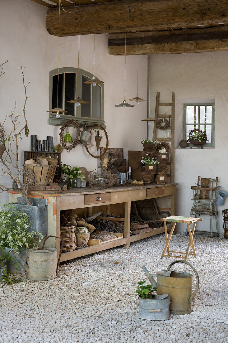 Old workbench as planting table with objects and decorative utensils in a courtyard