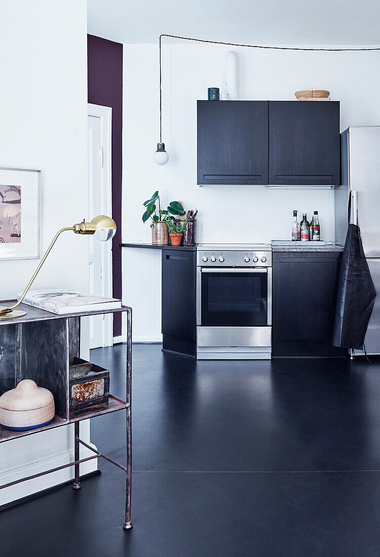 Küche mit schwarzen Schrankfronten und schwarzem Linoleumboden