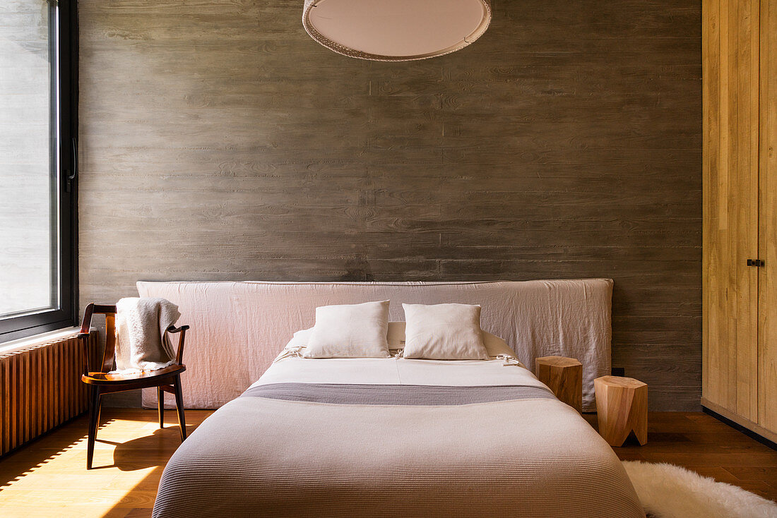 Sonniges Schlafzimmer in Naturtönen mit Betonwand