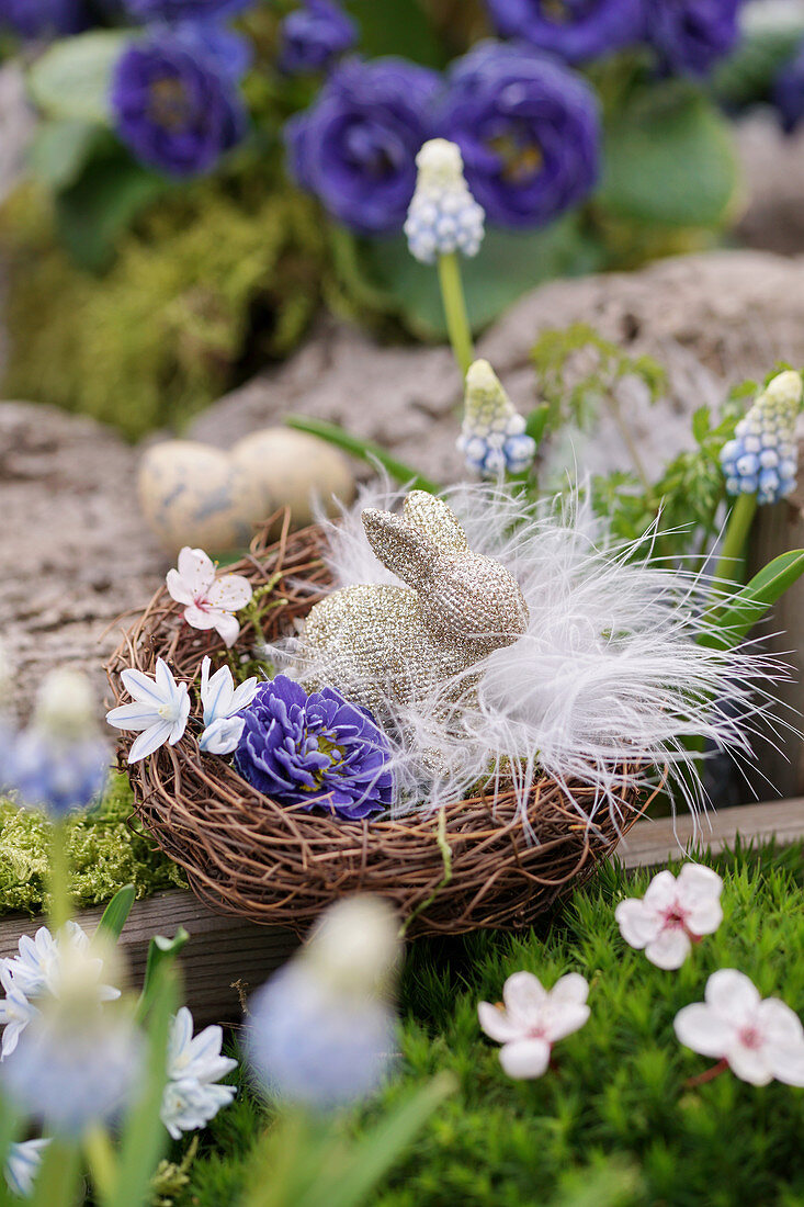Easter basket with flowers, feathers and Easter bunny