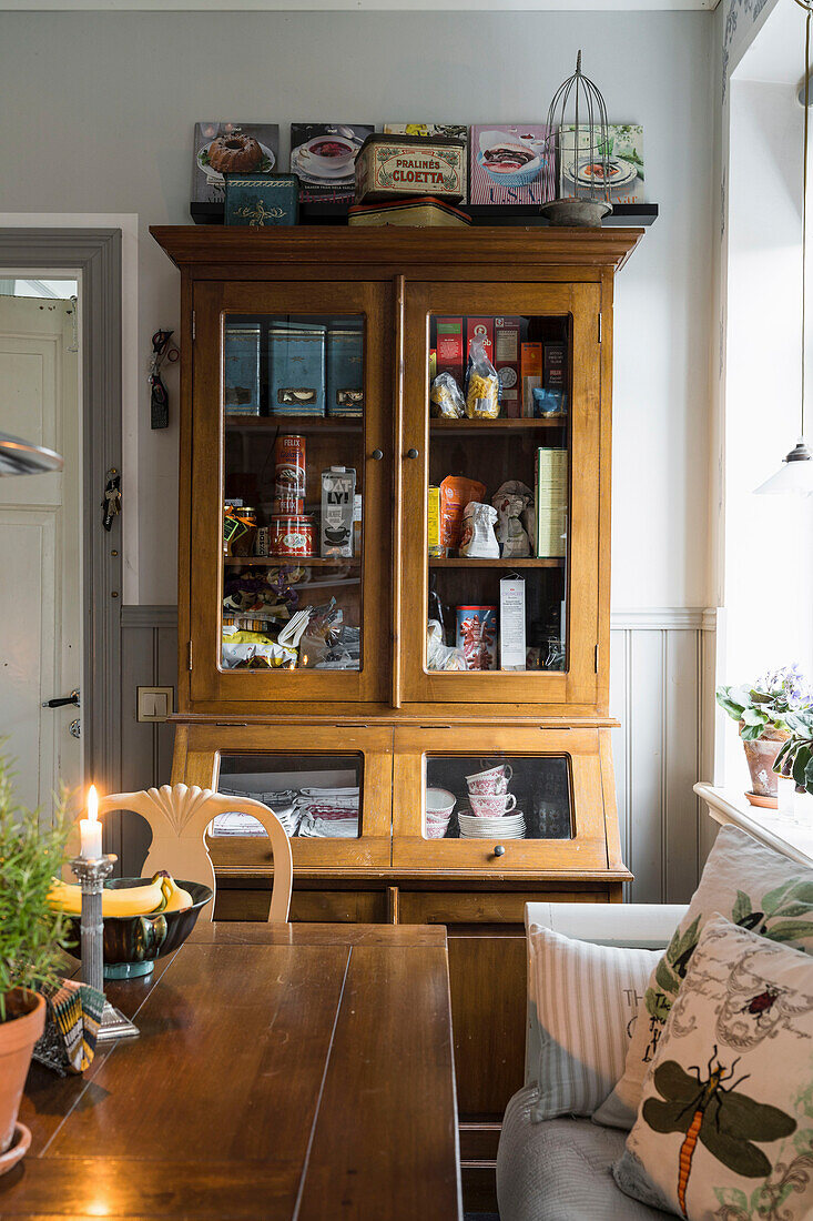 View across dining table to antique display cabinet