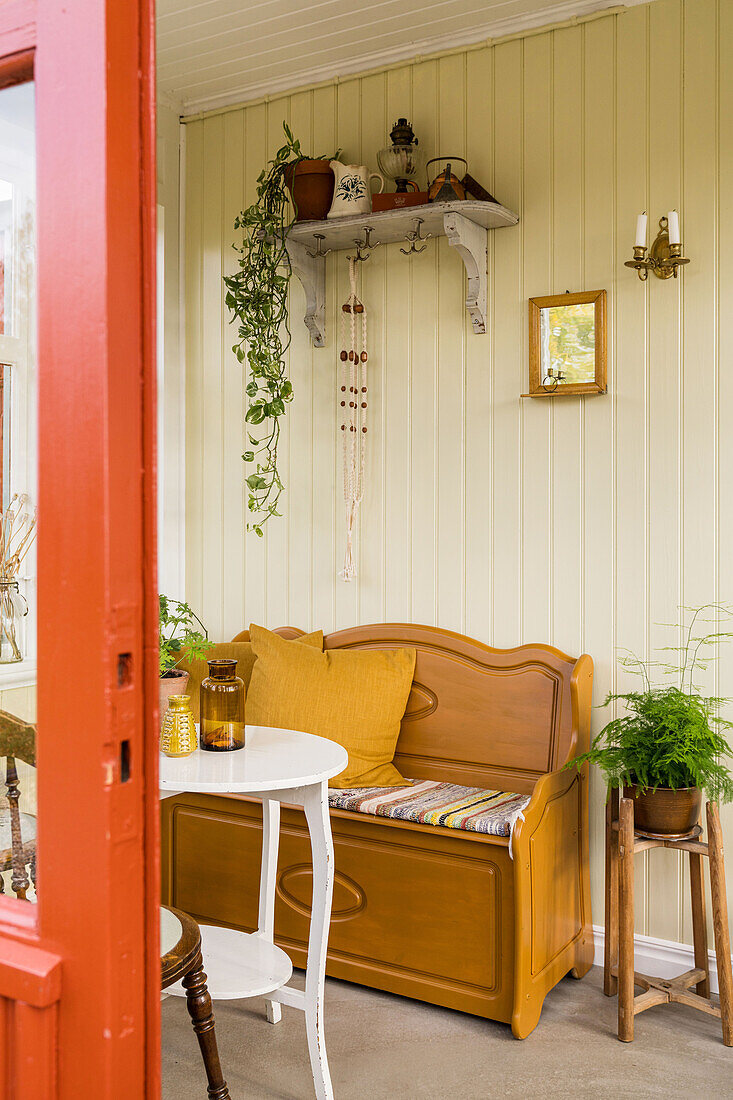 Chest bench and flea-market furniture in conservatory with yellow wall