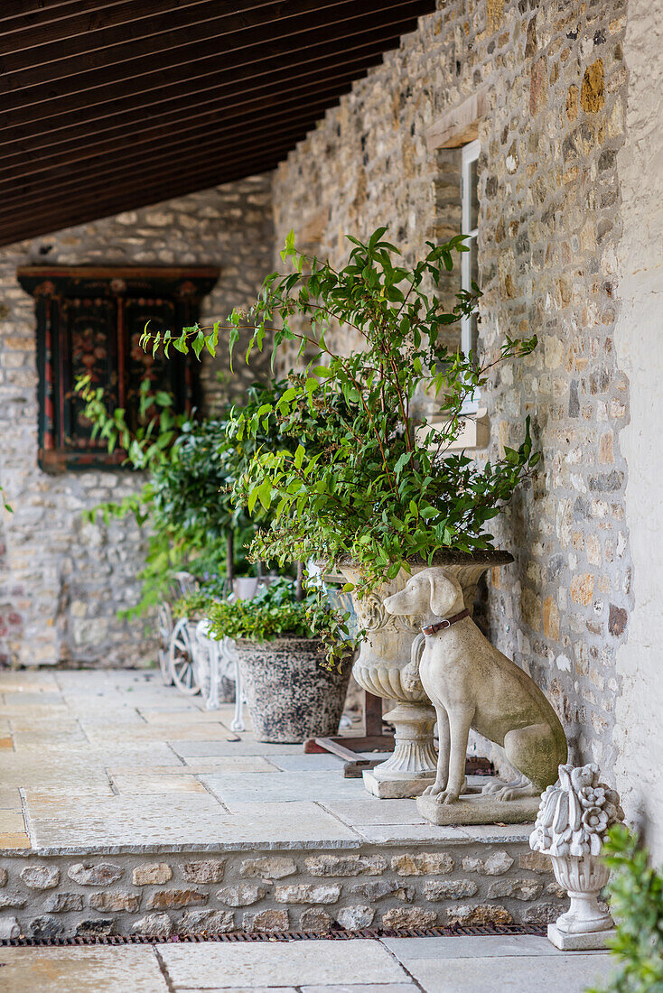 Steinhund neben Amphore auf der Terrasse am Steinhaus