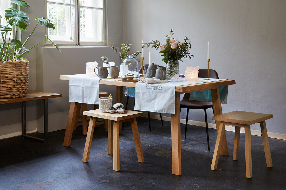 Gedeckter Tisch im Skandinavischen Stil mit Stühlen und Hockern