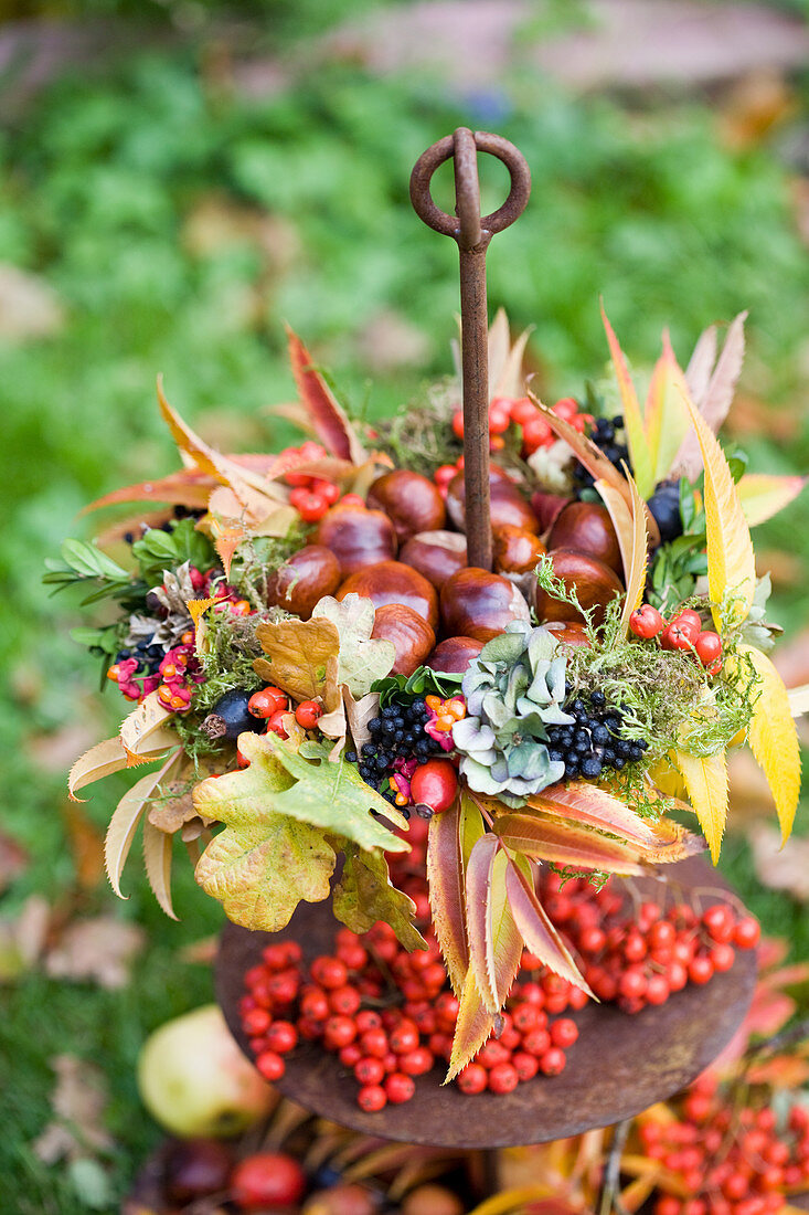 Kastanien im bunten Herbstkranz aus Herbstlaub und Beeren