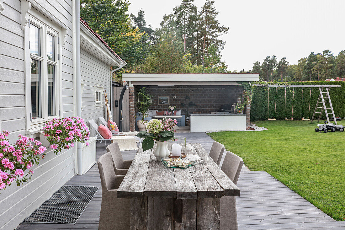 Rustic wooden table with elegant rattan chairs on the terrace