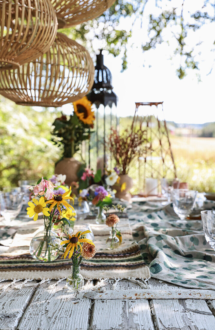 Gedeckter Tisch mit Blumendeko im Garten
