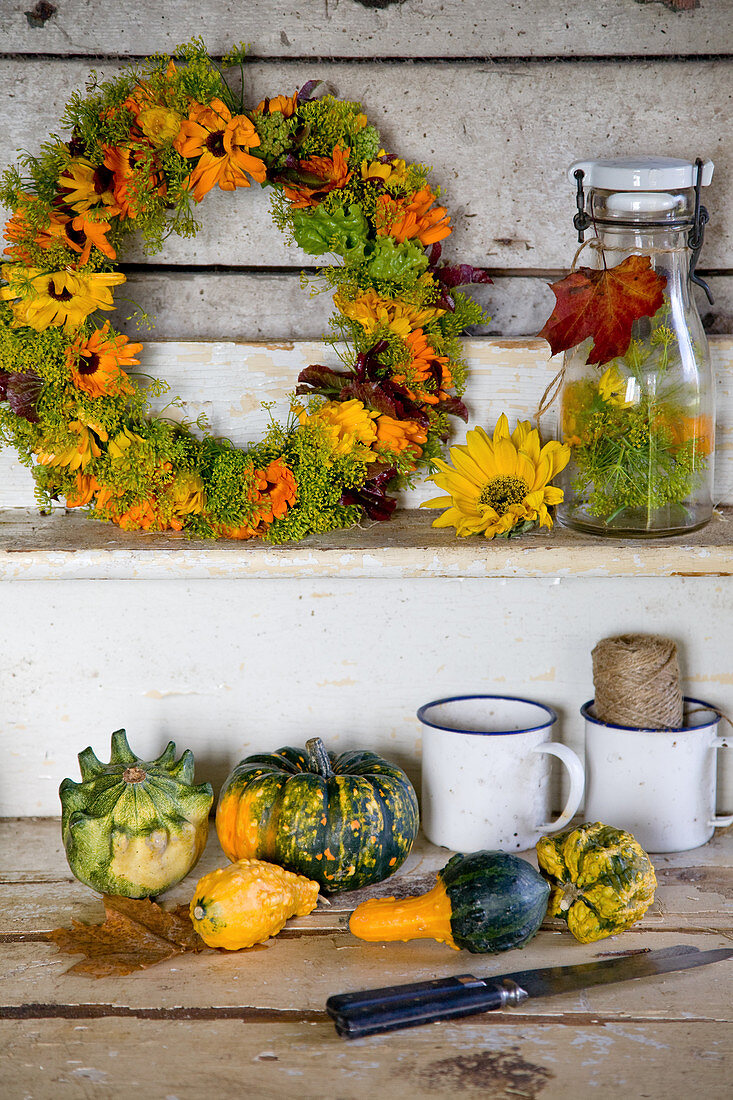 Autumn wreath of marigold blossoms and fennel, with ornamental pumpkins