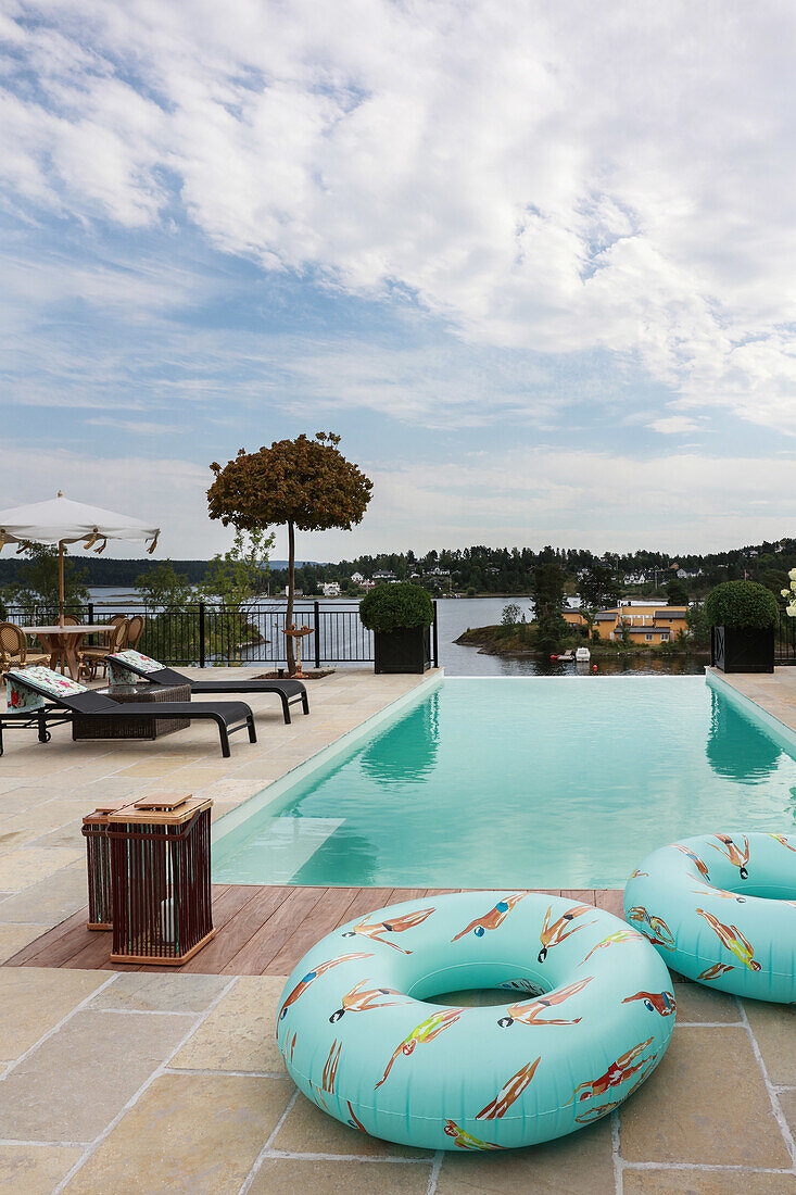 Rubber rings next to swimming with two sun loungers in the background